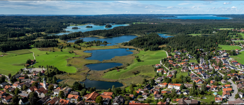Aerial view of Iffeldorf, Bavaria, with several interconnected lakes of the Osterseen lake district in the background. (c) Ann-Marie Waldvogel